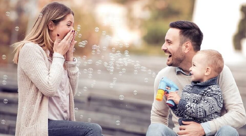 אמא, אבא וילד משחקים בבועות סבון